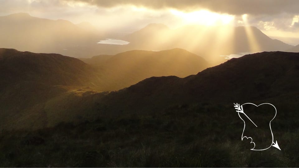 Sun bursting through clouds over Irish mountains